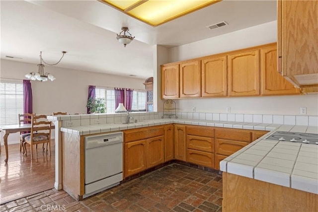 21509 Stage Dr, Tehachapi, CA 93561 - kitchen with white dishwasher, black electric stovetop, brick floors, and a chandelier