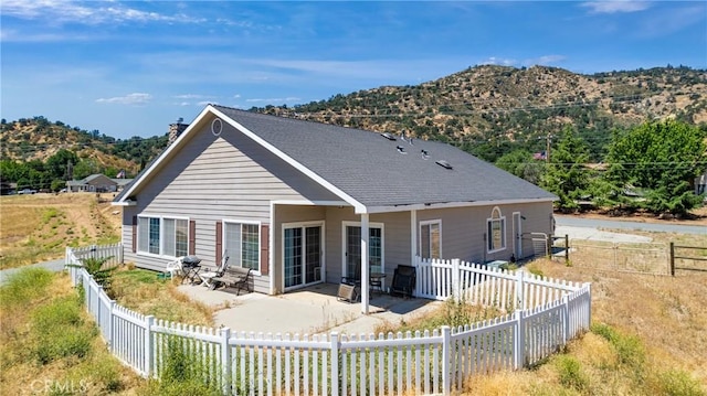 21509 Stage Dr, Tehachapi, CA 93561 - back of house with a mountain view, a patio, a chimney, and a fenced backyard