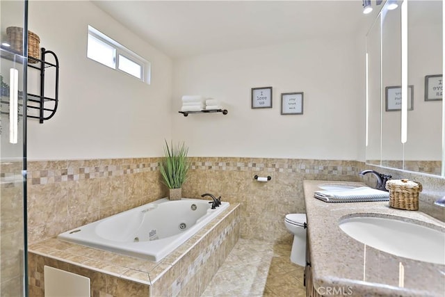 5066 N Nearglen Ave, Covina, CA 91724 - full bathroom featuring a whirlpool tub, vanity, tile walls, wainscoting, and tile patterned flooring