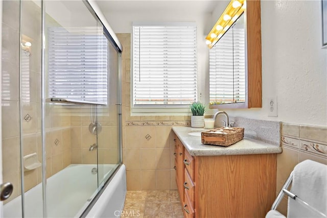 5066 N Nearglen Ave, Covina, CA 91724 - bathroom with tile walls, vanity, combined bath / shower with glass door, wainscoting, and tile patterned floors