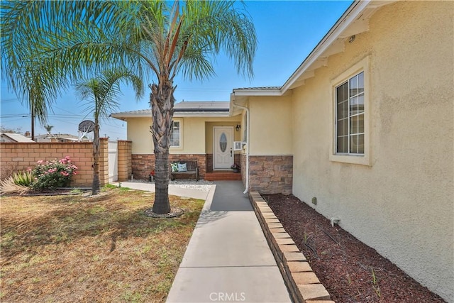 5066 N Nearglen Ave, Covina, CA 91724 - entrance to property featuring stucco siding, solar panels, and stone siding