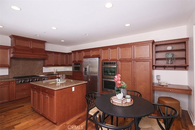 15681 Canon Ln, Chino Hills, CA 91709 - kitchen featuring stainless steel appliances, light wood finished floors, a center island, recessed lighting, and dark stone countertops