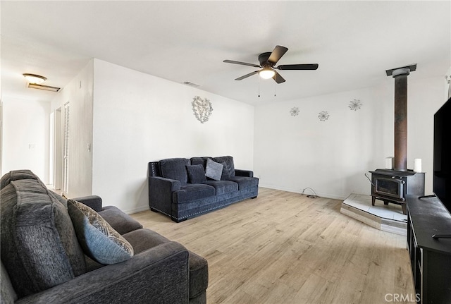 342 Rio Vista Ct, Corning, CA 96021 - living room with ceiling fan, light wood-style floors, and a wood stove