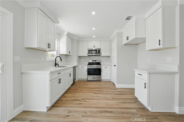 1717 Norval St, Pomona, CA 91766 - kitchen featuring appliances with stainless steel finishes, recessed lighting, light wood-style floors, white cabinets, and light countertops