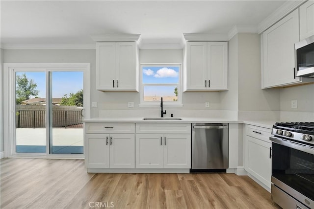1717 Norval St, Pomona, CA 91766 - kitchen featuring appliances with stainless steel finishes, light wood-type flooring, light countertops, white cabinetry, and ornamental molding