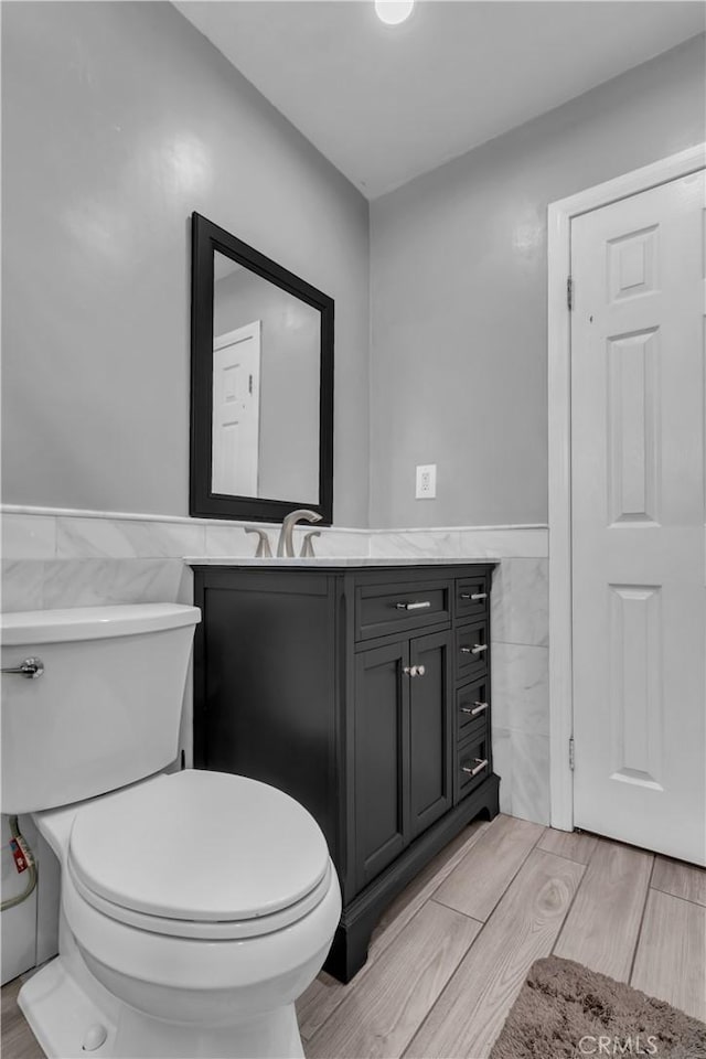 1109 Broadmoor Ave, La Puente, CA 91744 - half bath with tile walls, vanity, a wainscoted wall, and wood finished floors
