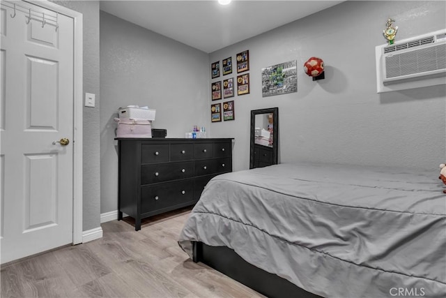 1109 Broadmoor Ave, La Puente, CA 91744 - bedroom with wood finished floors, an AC wall unit, and a textured wall