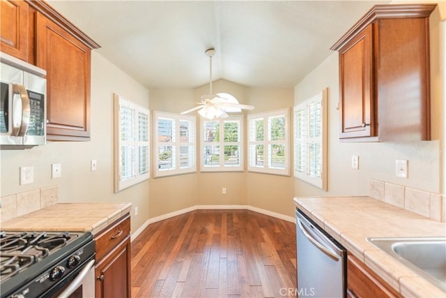 6419 Panorama Ct, Rancho Cucamonga, CA 91737 - kitchen featuring stainless steel appliances, tile countertops, dark wood-style floors, ceiling fan, and brown cabinets