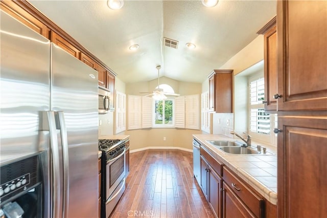 6419 Panorama Ct, Rancho Cucamonga, CA 91737 - kitchen with stainless steel appliances, tile counters, vaulted ceiling, dark wood-type flooring, and brown cabinetry