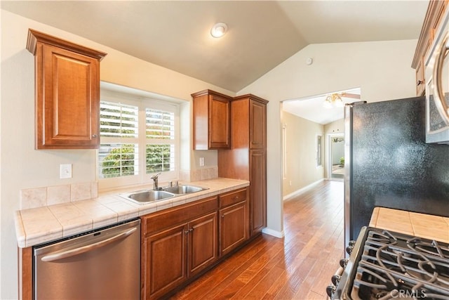 6419 Panorama Ct, Rancho Cucamonga, CA 91737 - kitchen featuring stainless steel appliances, vaulted ceiling, wood finished floors, tile countertops, and brown cabinetry