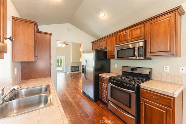 6419 Panorama Ct, Rancho Cucamonga, CA 91737 - kitchen with appliances with stainless steel finishes, lofted ceiling, dark wood finished floors, tile counters, and brown cabinets