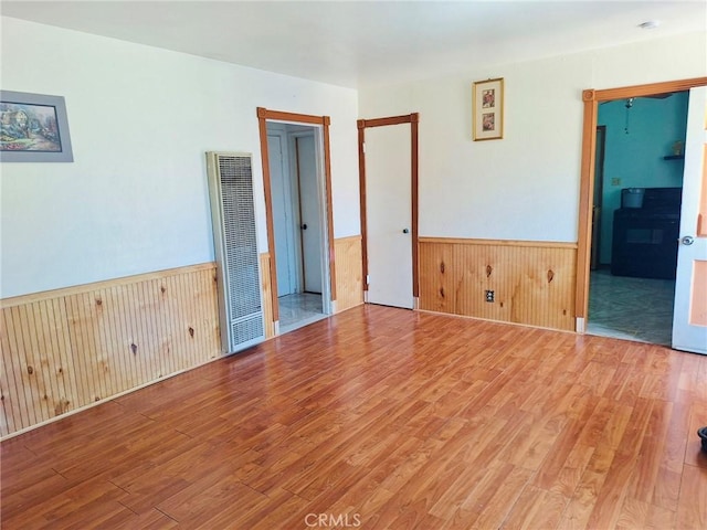 3424 Christie Ct, Sacramento, CA 95838 - spare room with a heating unit, light wood-type flooring, wainscoting, and wooden walls