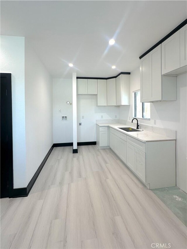 1295 E Whittier Ave, Hemet, CA 92543 - kitchen with light wood-type flooring, white cabinetry, recessed lighting, and light countertops