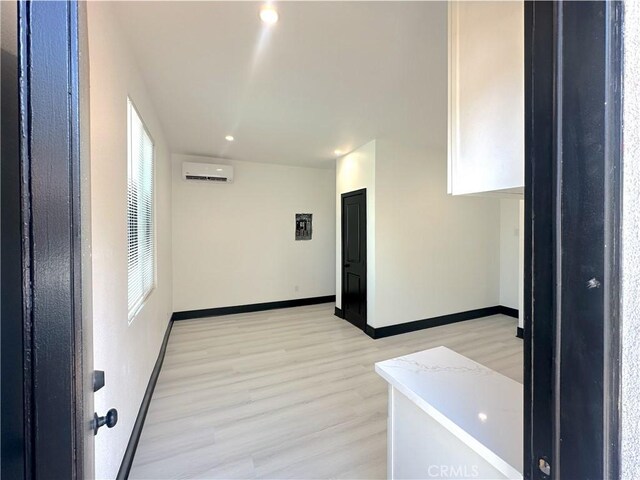 1295 E Whittier Ave, Hemet, CA 92543 - unfurnished room with an AC wall unit, light wood finished floors, and recessed lighting