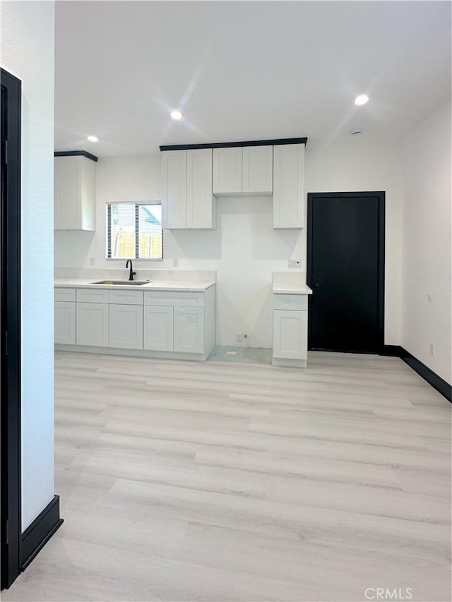 1295 E Whittier Ave, Hemet, CA 92543 - kitchen with light wood finished floors, white cabinets, recessed lighting, and light countertops