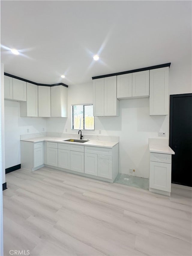 1295 E Whittier Ave, Hemet, CA 92543 - kitchen featuring light wood-style floors, recessed lighting, white cabinetry, and light countertops