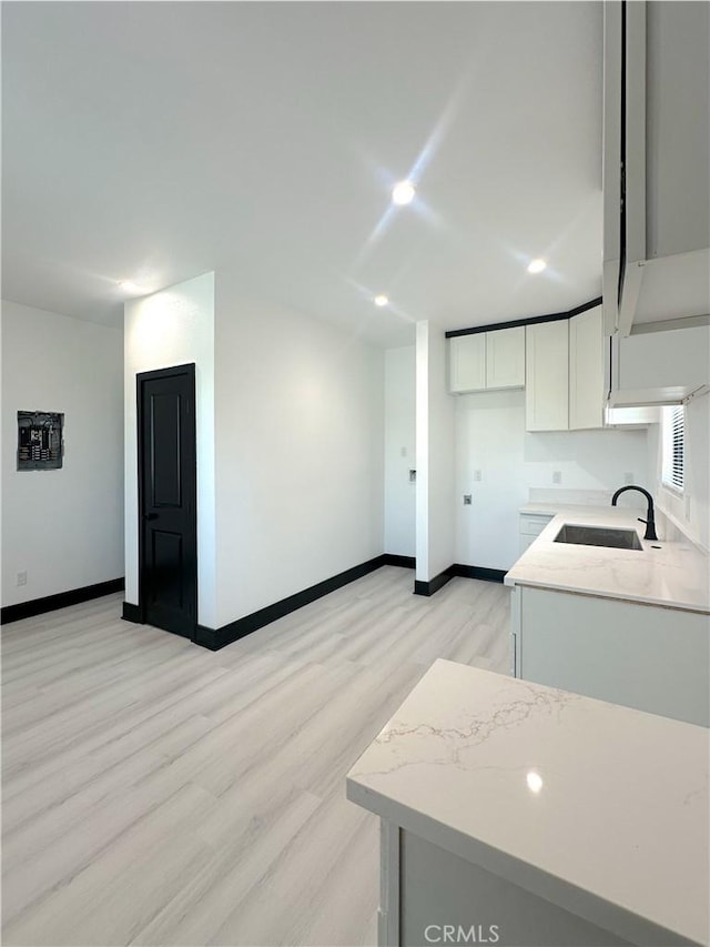 1295 E Whittier Ave, Hemet, CA 92543 - kitchen with light wood-style floors, white cabinetry, recessed lighting, and light stone countertops