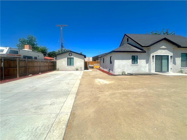 1295 E Whittier Ave, Hemet, CA 92543 - view of front of home with a fenced backyard, stucco siding, an outbuilding, and a patio area