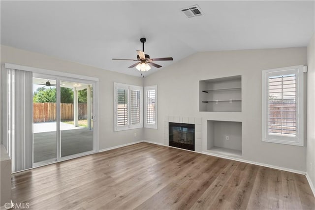 6327 W W Ave J5, Lancaster, CA 93536 - unfurnished living room with built in features, a ceiling fan, plenty of natural light, wood finished floors, and vaulted ceiling