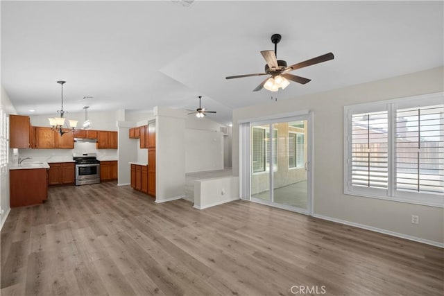 6327 W W Ave J5, Lancaster, CA 93536 - unfurnished living room with lofted ceiling, light wood finished floors, ceiling fan, and a chandelier
