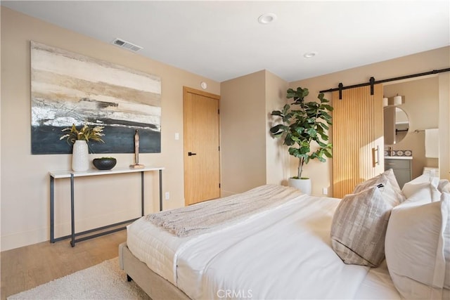 3273 Tilden Ave, Los Angeles, CA 90034 - bedroom with a barn door, wood finished floors, and recessed lighting