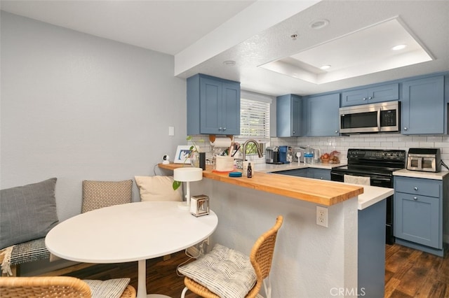 8718 E Indian Hills Rd Unit J, Orange, CA 92869 - kitchen with stainless steel microwave, blue cabinetry, tasteful backsplash, dark wood-style floors, and recessed lighting