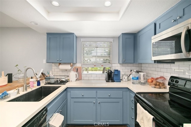 8718 E Indian Hills Rd Unit J, Orange, CA 92869 - kitchen with black electric range oven, stainless steel microwave, a tray ceiling, blue cabinetry, and decorative backsplash