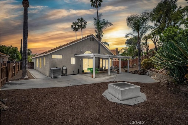 24322 Via Las Junitas, Murrieta, CA 92562 - back of property at dusk featuring stucco siding, a fenced backyard, and a patio