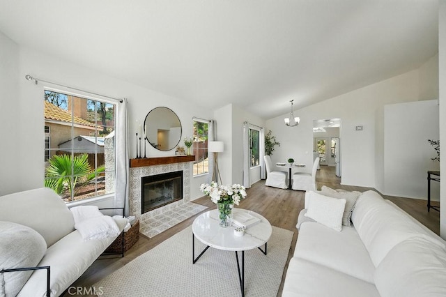 24322 Via Las Junitas, Murrieta, CA 92562 - living room featuring vaulted ceiling, a chandelier, a fireplace, and wood finished floors