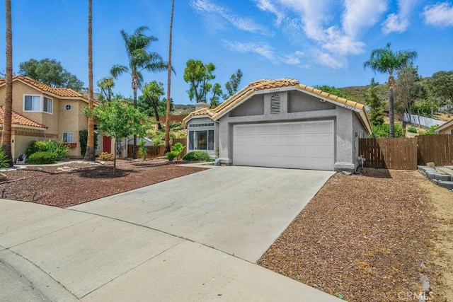 24322 Via Las Junitas, Murrieta, CA 92562 - view of front facade with an attached garage, driveway, stucco siding, and a tile roof