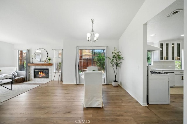 24322 Via Las Junitas, Murrieta, CA 92562 - dining area with wood finished floors, a chandelier, a tiled fireplace, and recessed lighting