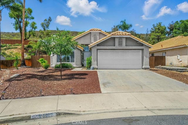 24322 Via Las Junitas, Murrieta, CA 92562 - view of front facade with stucco siding, a garage, a tile roof, and concrete driveway
