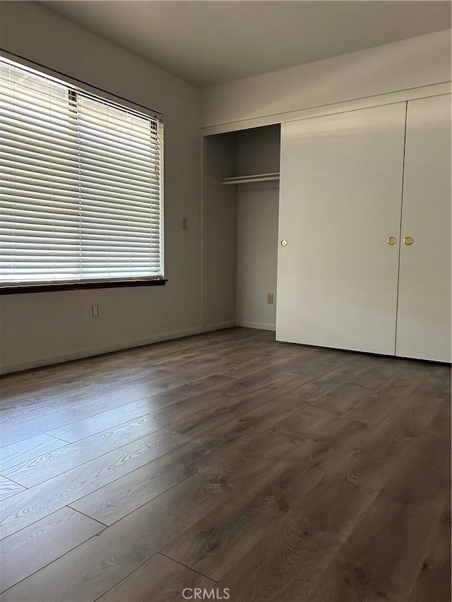 13915 Spring Valley Pkwy, Victorville, CA 92395 - unfurnished bedroom with dark wood-style flooring and a closet