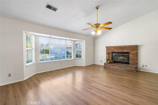 903 San Pablo Ave, Merced, CA 95348 - unfurnished living room featuring wood finished floors, ceiling fan, vaulted ceiling, and a brick fireplace