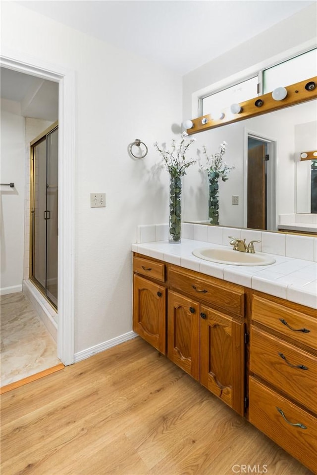 903 San Pablo Ave, Merced, CA 95348 - bathroom featuring vanity, a shower stall, and wood finished floors