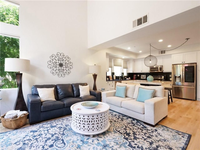 5429 Strand Unit 101, Hawthorne, CA 90250 - living area with light wood-type flooring, a towering ceiling, and recessed lighting