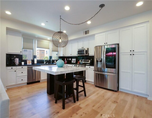 5429 Strand Unit 101, Hawthorne, CA 90250 - kitchen with stainless steel appliances, white cabinetry, backsplash, a kitchen island, and recessed lighting