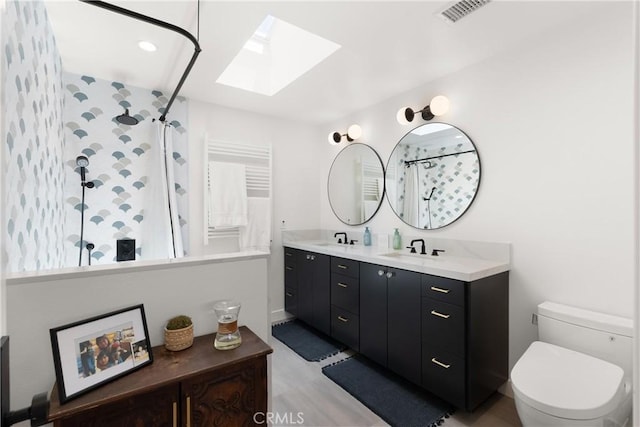 20 Whistling Isle, Irvine, CA 92614 - bathroom featuring a skylight, tiled shower, double vanity, and a towel warming rack
