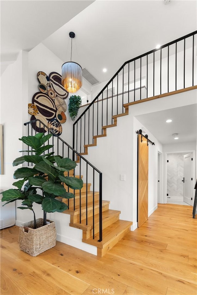 20 Whistling Isle, Irvine, CA 92614 - staircase featuring hardwood / wood-style flooring, a chandelier, a barn door, and recessed lighting