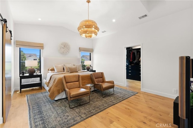 20 Whistling Isle, Irvine, CA 92614 - bedroom featuring a barn door, light wood finished floors, lofted ceiling, and a walk in closet