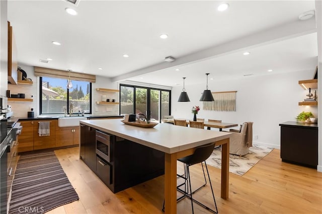 20 Whistling Isle, Irvine, CA 92614 - kitchen featuring open shelves, light wood-style floors, a kitchen island, recessed lighting, and stainless steel microwave