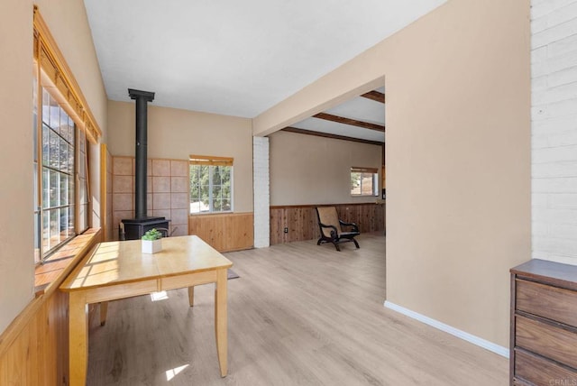 37882 Montezuma Valley Rd, Ranchita, CA 92066 - dining space featuring a wood stove, wainscoting, beamed ceiling, wooden walls, and wood finished floors
