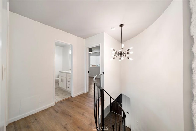 240 W Queen St Unit 10, Inglewood, CA 90301 - hallway featuring an upstairs landing, light wood-style flooring, and a chandelier