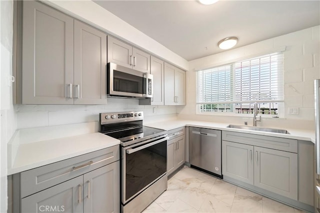 240 W Queen St Unit 10, Inglewood, CA 90301 - kitchen featuring stainless steel appliances, gray cabinetry, light marble finish floors, and light countertops