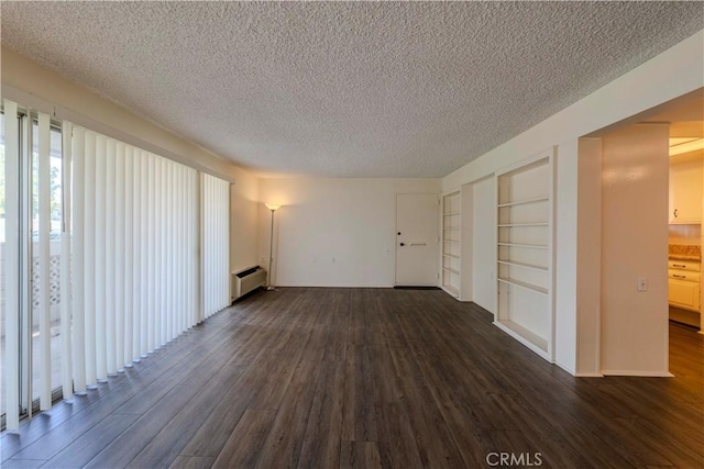 368 Avenida Castilla Unit B, Laguna Woods, CA 92637 - unfurnished living room with a baseboard radiator, a textured ceiling, dark wood-style flooring, and built in shelves