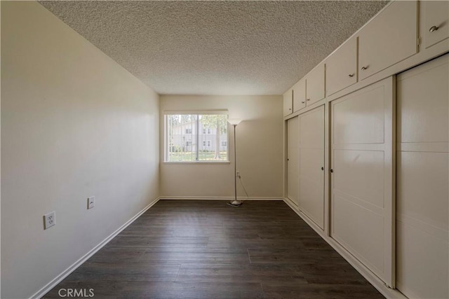 368 Avenida Castilla Unit B, Laguna Woods, CA 92637 - unfurnished bedroom with a textured ceiling and dark wood-type flooring