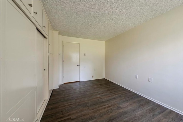 368 Avenida Castilla Unit B, Laguna Woods, CA 92637 - unfurnished bedroom featuring a textured ceiling, dark wood-style flooring, and a closet