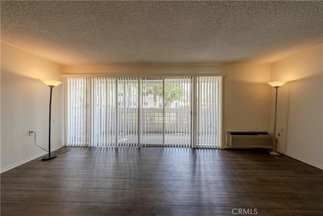 368 Avenida Castilla Unit B, Laguna Woods, CA 92637 - unfurnished room with wood-type flooring, a textured ceiling, and a wall mounted AC