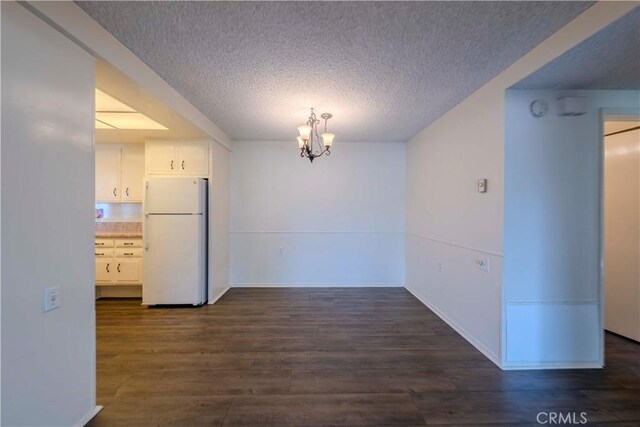 368 Avenida Castilla Unit B, Laguna Woods, CA 92637 - unfurnished dining area with dark wood-type flooring, a textured ceiling, and a chandelier