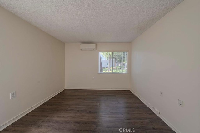 368 Avenida Castilla Unit B, Laguna Woods, CA 92637 - unfurnished room with an AC wall unit, a textured ceiling, and dark wood-type flooring